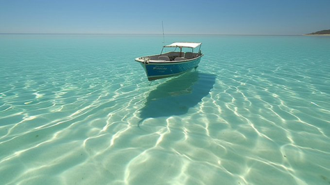 An optical illusion created by extremely clear glass-like water, The water is so clear, ethereal, boat shadow is completely detached...