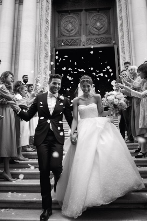 street style photo, full body shot of bride and groom walking down church steps, bride and groom smiling, long cathedral...